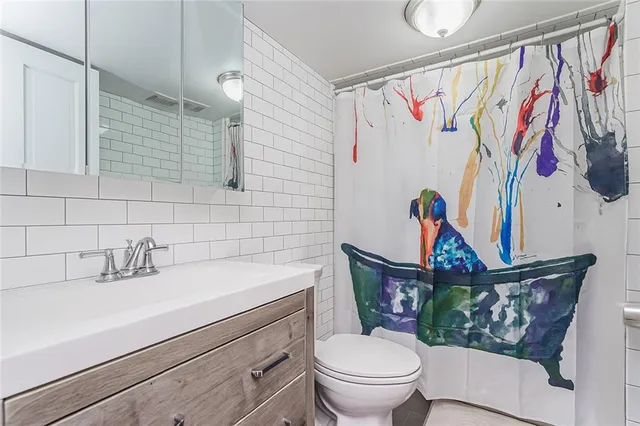 a bathroom with a toilet sink and mirror