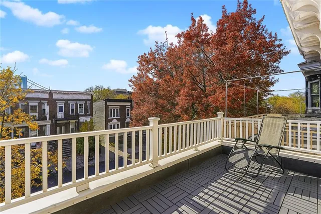 a view of a brick house with a wooden deck