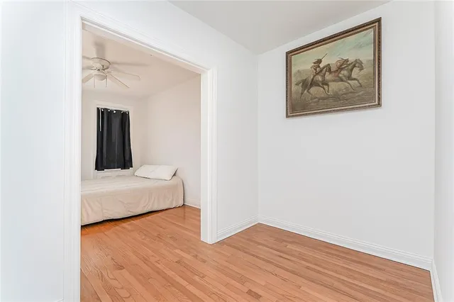 a view of a bedroom with a bed and wooden floor