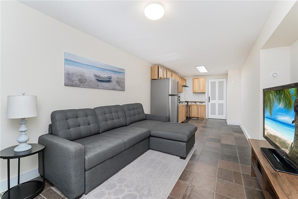 227 94th Street Brooklyn, NY 11209 - Photo 24 of 34 a living room with furniture and a flat screen tv