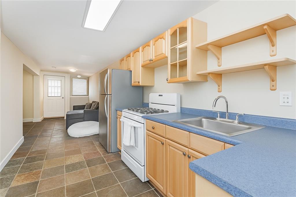 227 94th Street Brooklyn, NY 11209 - Photo 28 of 34 a kitchen with a sink cabinets and appliances