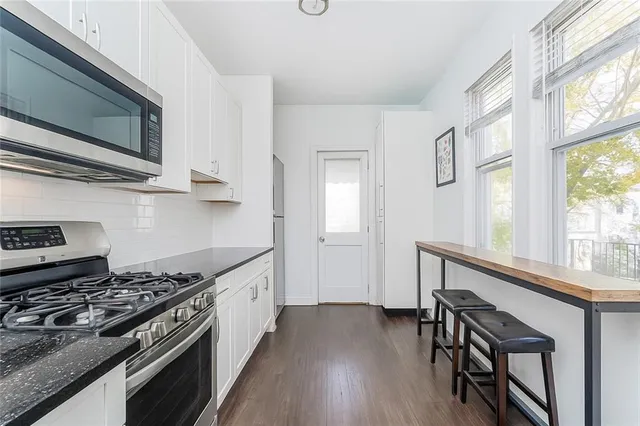 a kitchen with stainless steel appliances a stove a sink and a microwave