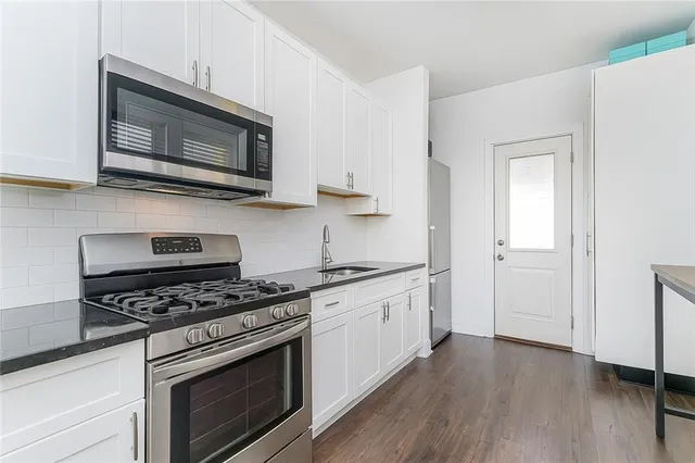 a kitchen with stainless steel appliances granite countertop a stove microwave and sink