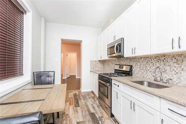 a kitchen with granite countertop a sink cabinets and stainless steel appliances