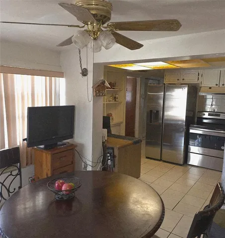 a living room with stainless steel appliances furniture and a flat screen tv