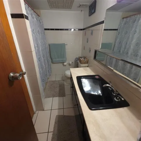 a bedroom with a bed and a flat tv screen on dresser