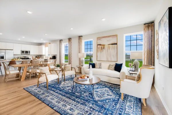 a living room with furniture large window and wooden floor