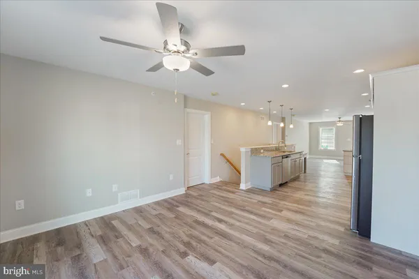 a view of a kitchen with kitchen island a refrigerator stove a sink dishwasher with a dining table and chairs