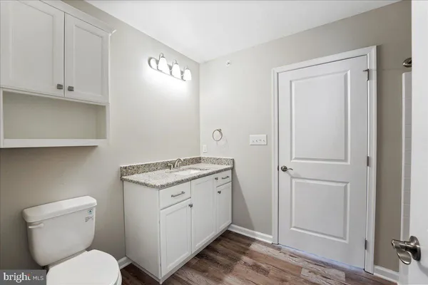 a bathroom with a granite countertop toilet and sink