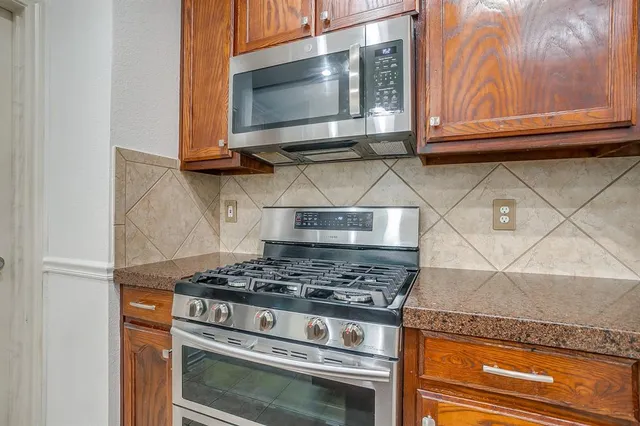 a kitchen with granite countertop cabinets and steel stainless steel appliances