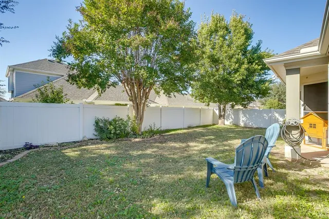 a view of a backyard with table and chairs and a tree