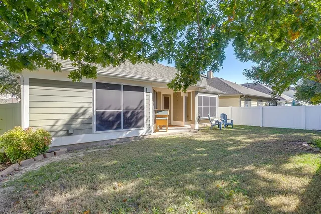 a view of a house with a yard and large tree