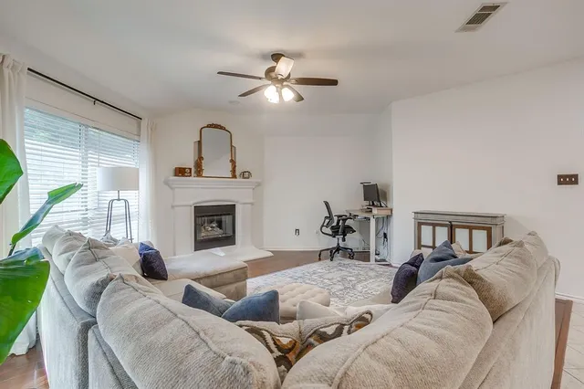 a living room with furniture a fireplace and a large window