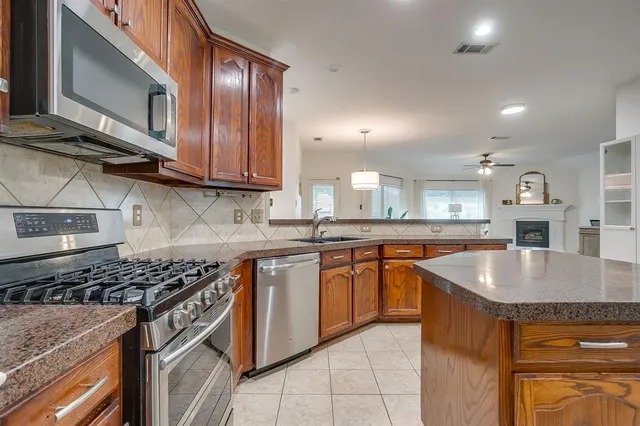 a kitchen with stainless steel appliances granite countertop a sink stove and cabinets