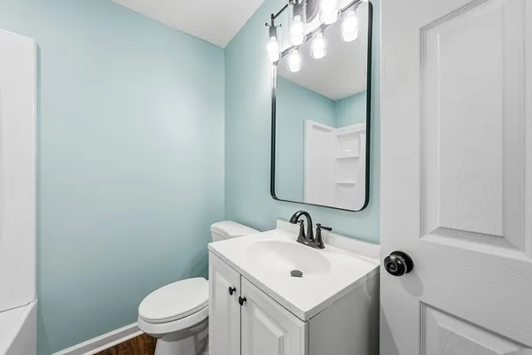 a bathroom with a toilet a sink and mirror