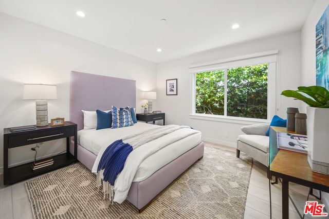 a bed room with a bed and a painting on the wall