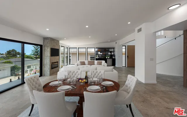 a dining room with furniture and a floor to ceiling window