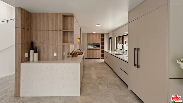 a large white kitchen with kitchen island granite countertop a refrigerator and a sink
