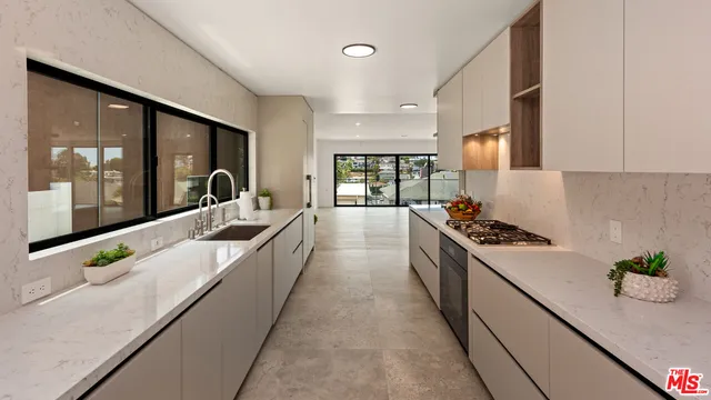 a large kitchen with stainless steel appliances granite countertop a lot of counter space and wooden floors