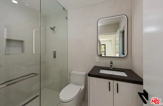 a bathroom with a toilet sink shower and mirror