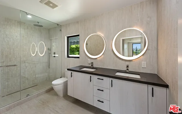 a bathroom with a double vanity sink mirror and toilet