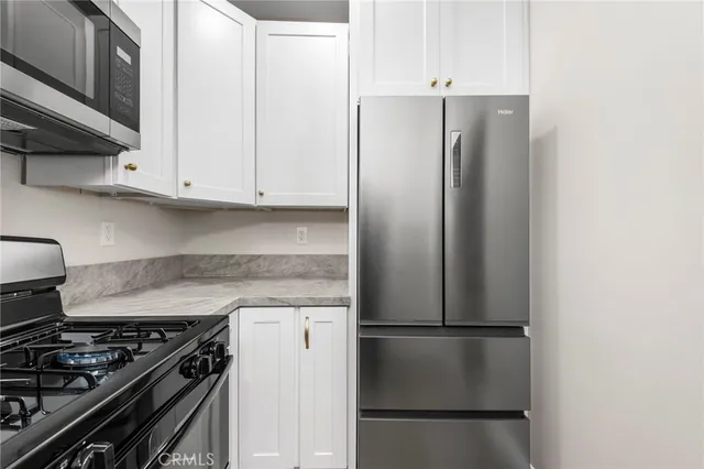 a kitchen with stainless steel appliances granite countertop a refrigerator and a stove