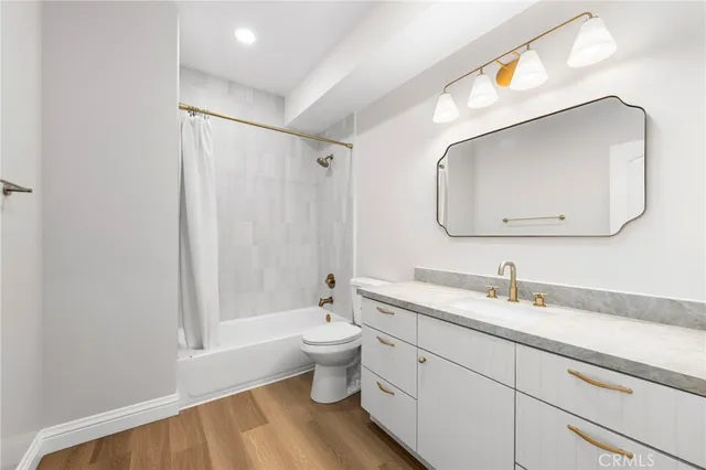 a bathroom with a toilet sink double vanity and mirror