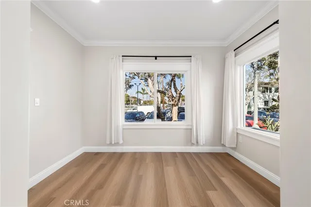 an empty room with windows and wooden floor