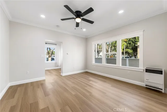 a view of an empty room with a window and wooden floor