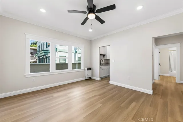 a view of an empty room with a window and wooden floor