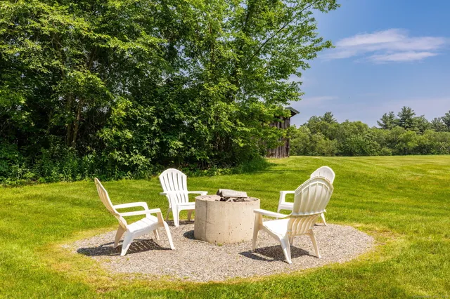 a table and chair sitting in the grass near a lake