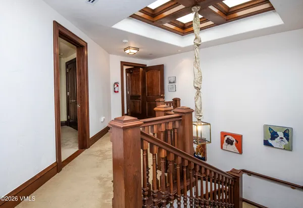 a dining room with wooden floor a chandelier a wooden table and chairs