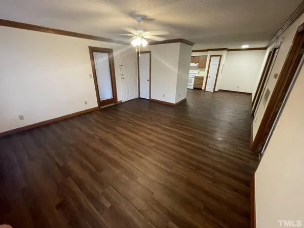 a view of empty room with wooden floor