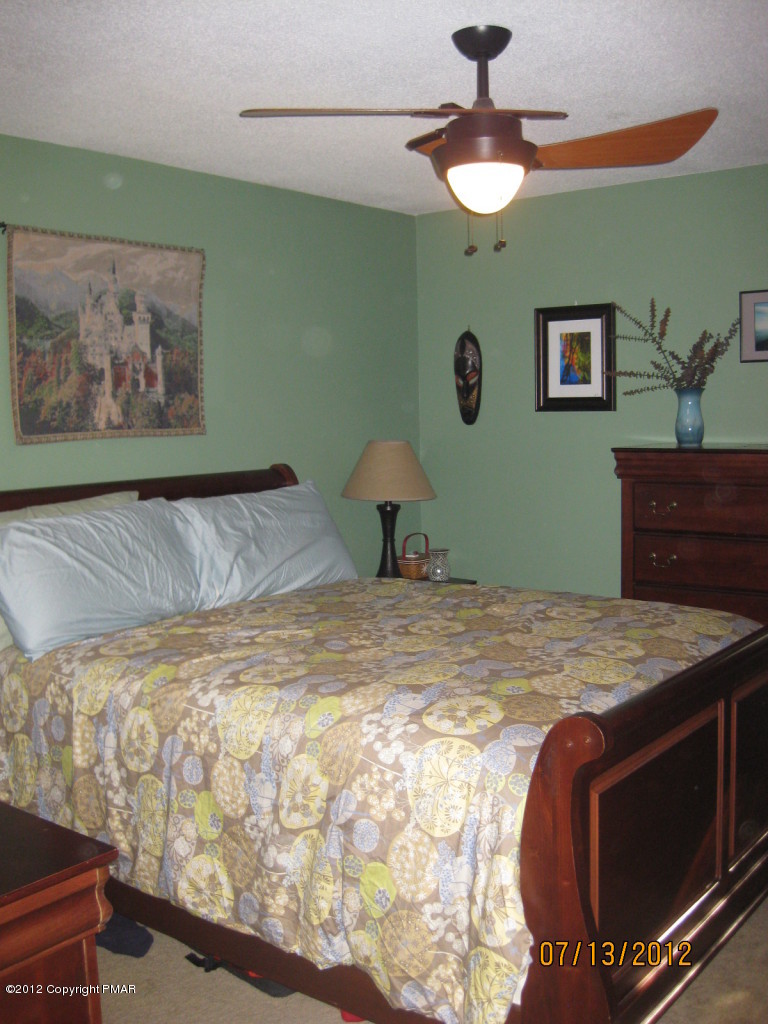 116 Grouse Road East Stroudsburg, PA 18301 - Photo 9 of 31 a bedroom with a bed and a chandelier