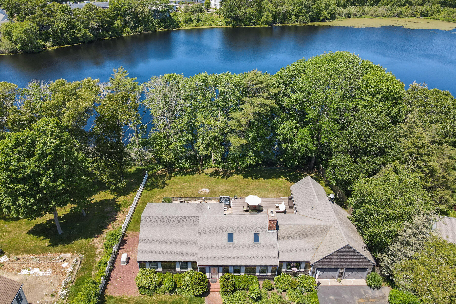 an aerial view of a house with swimming pool and lake view