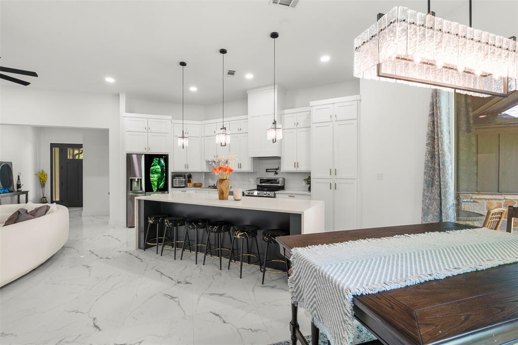 265 Shadow Oaks Streetman, TX 75859 - Photo 12 of 40 a kitchen with kitchen island stainless steel appliances a dining table and chairs