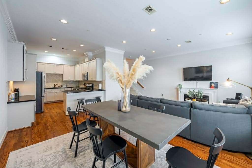 a living room with stainless steel appliances furniture a dining table and kitchen view