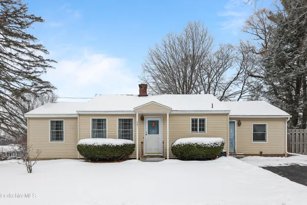a view of a house with a yard covered in snow