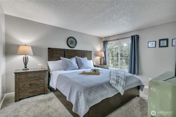 a bedroom with a bed a lamp and a window