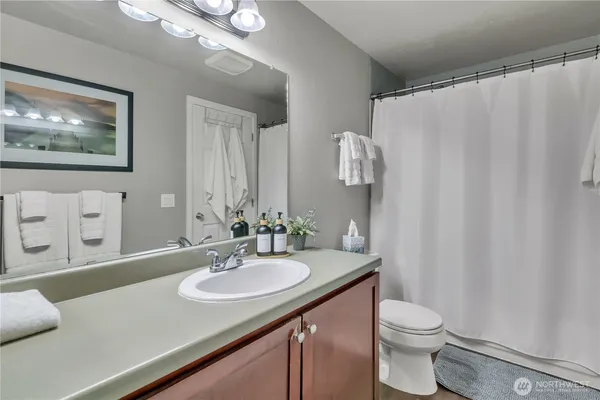 a bathroom with a sink a toilet and mirror