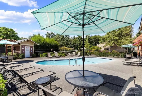 a patio with a table and chairs under an umbrella
