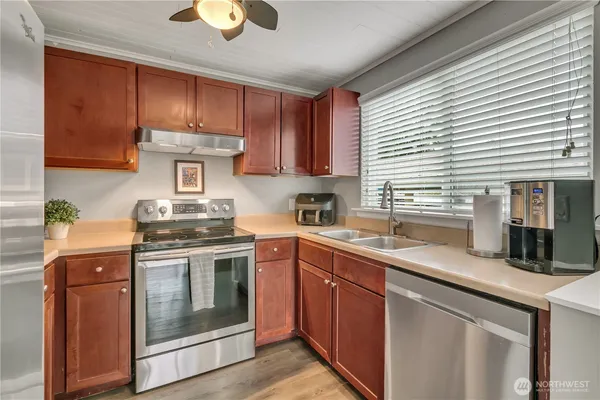 a kitchen with stainless steel appliances granite countertop a stove a sink and a microwave