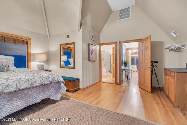 a bedroom with a large bed and a wooden floor