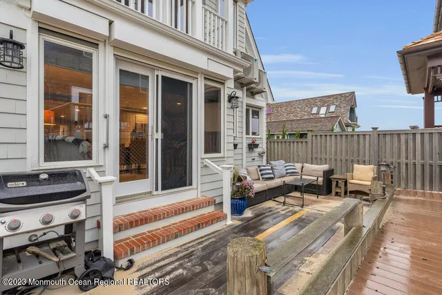 a view of a patio with table and chairs with wooden floor and fence