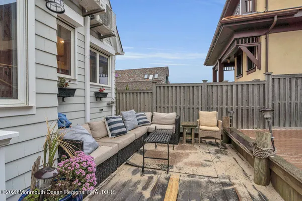 a view of a patio with couches table and chairs and potted plants