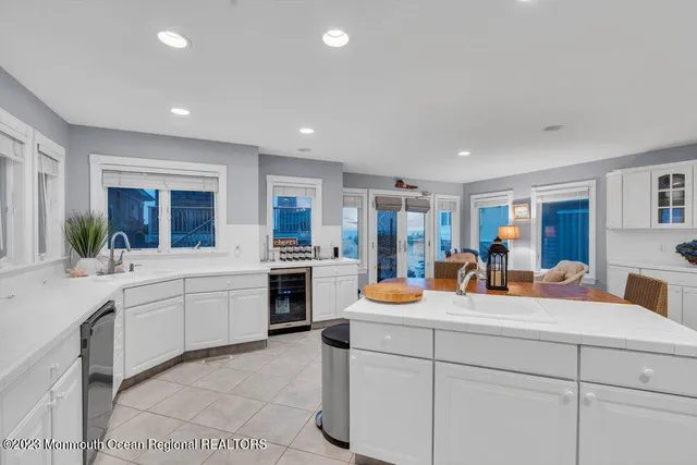 a large white kitchen with sink and white cabinets