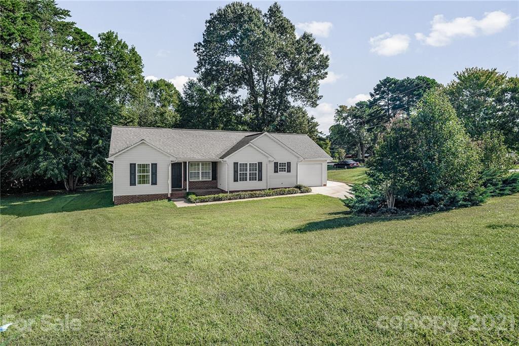 8577 Unity Church Road Denver, NC 28037 - Photo 2 of 33 a view of a white house with a big yard and large trees