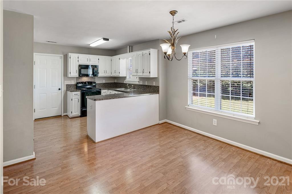 8577 Unity Church Road Denver, NC 28037 - Photo 14 of 33 a view of a kitchen with a stove wooden floor and a window
