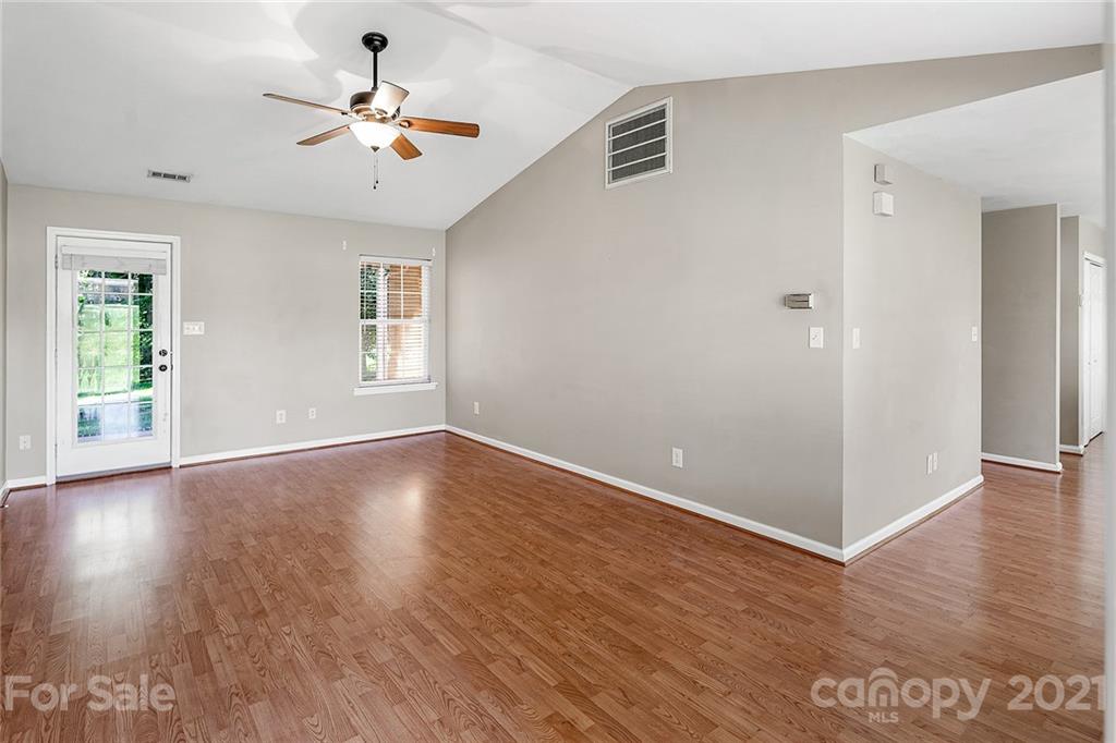 8577 Unity Church Road Denver, NC 28037 - Photo 5 of 33 an empty room with wooden floor chandelier fan and windows