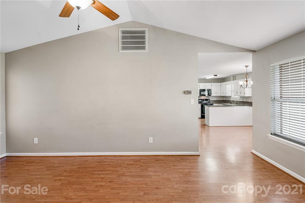 8577 Unity Church Road Denver, NC 28037 - Photo 6 of 33 a view of a kitchen with wooden floor and a ceiling fan